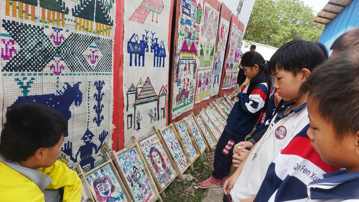 14.勐龙镇中心小学学生在欣赏自己的作品.jpg